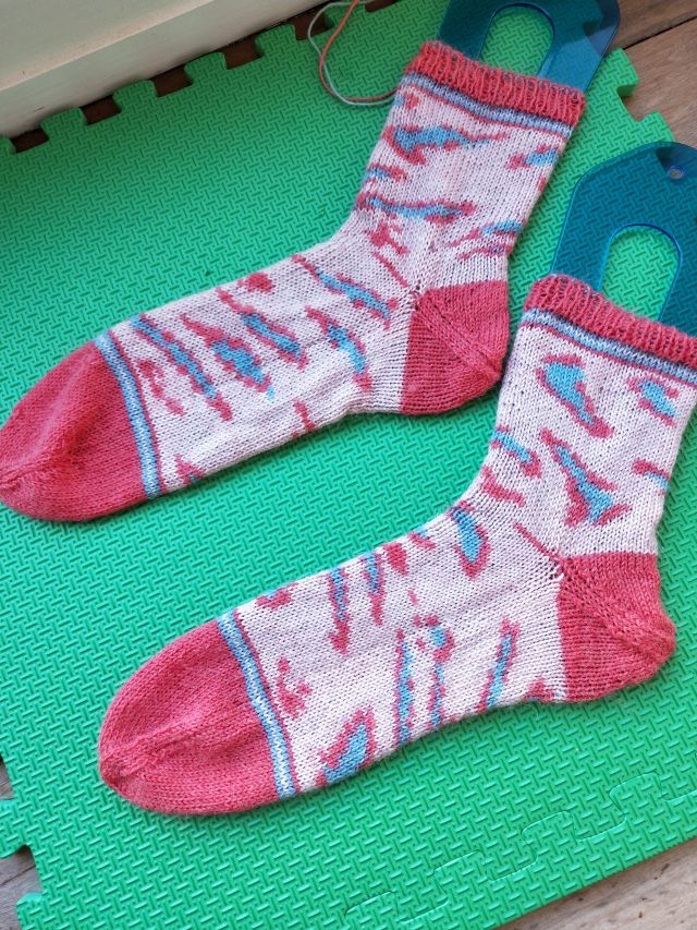 Image of Wool and the Gang's Kinda Magic socks - socks with a light pink ground with blue and darker print leopard spots and darker pink toes and heels